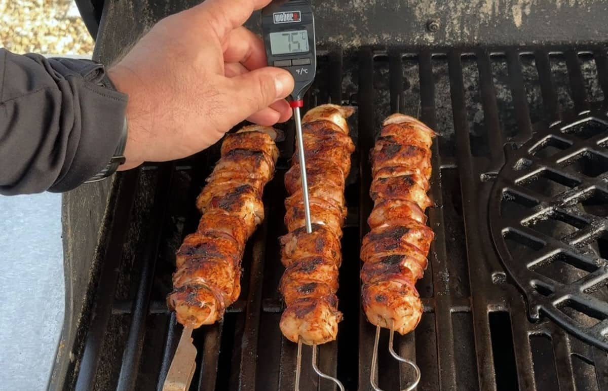 Misurazione spiedini di pollo con termometro per carne