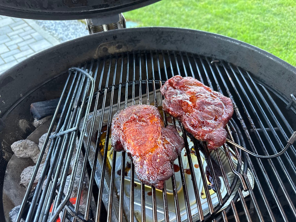 Bistecche di coppa di maiale che cuociono lentamente sul barbecue, ароматiche e succulente